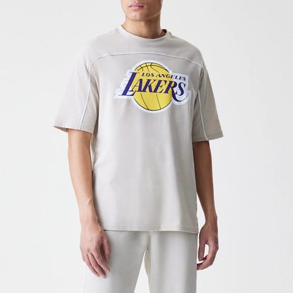 The Male model is wearing LA Lakers NBA Piping Light Beige Oversized T-Shirt 1