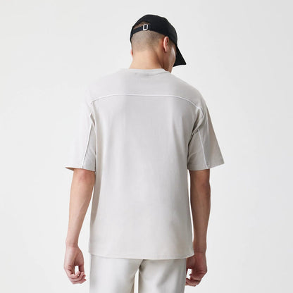 The Male model is wearing LA Lakers NBA Piping Light Beige Oversized T-Shirt 2